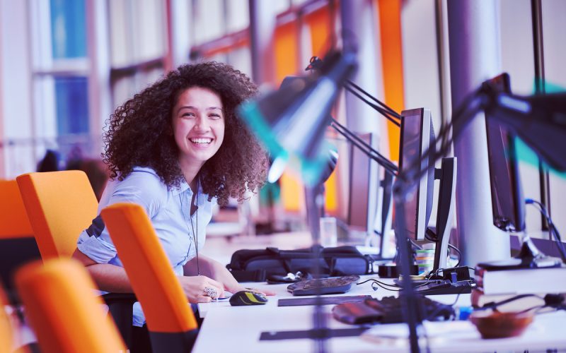 happy young  business woman with curly hairstyle in the modern office